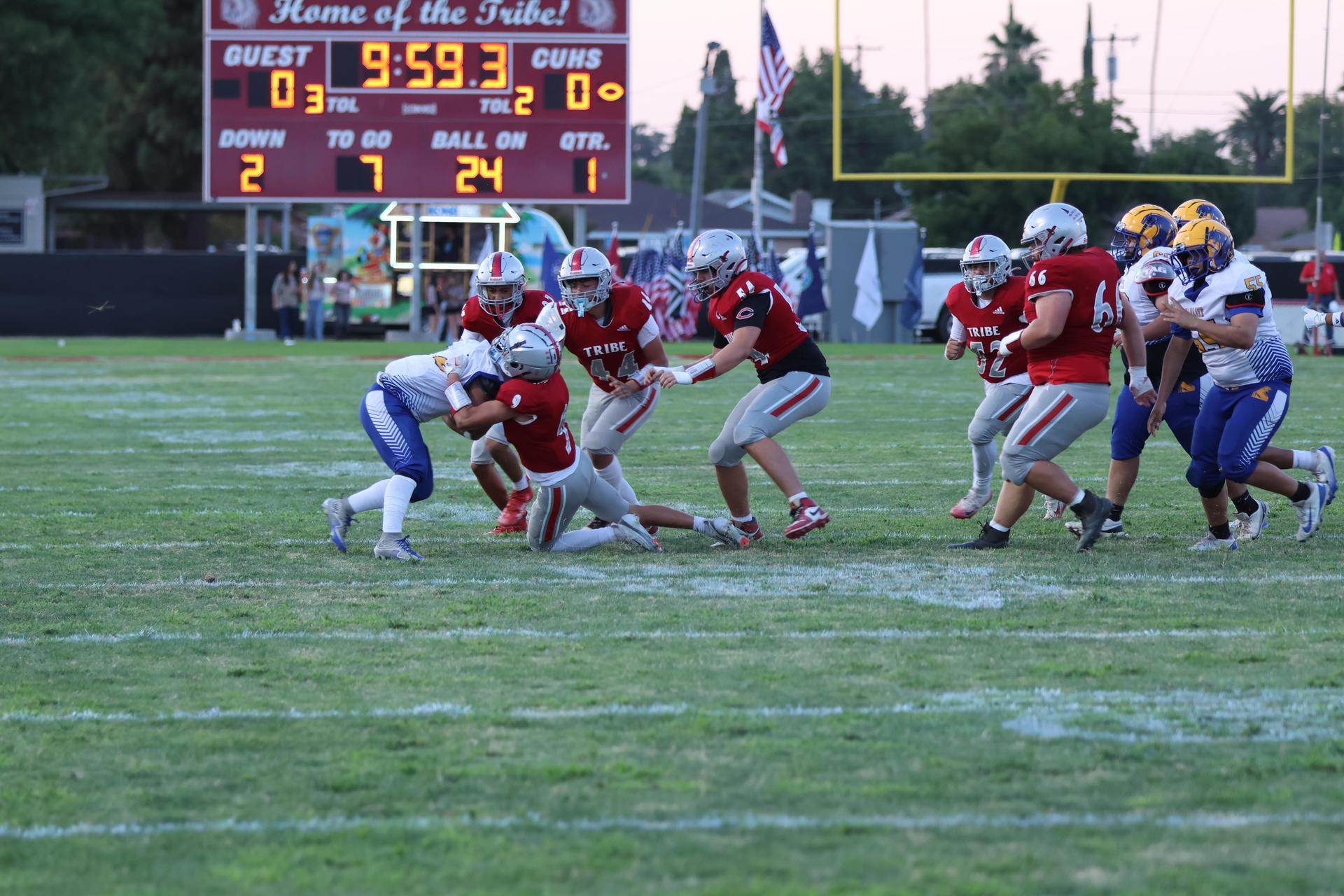 Varsity football players in action against Parlier 2