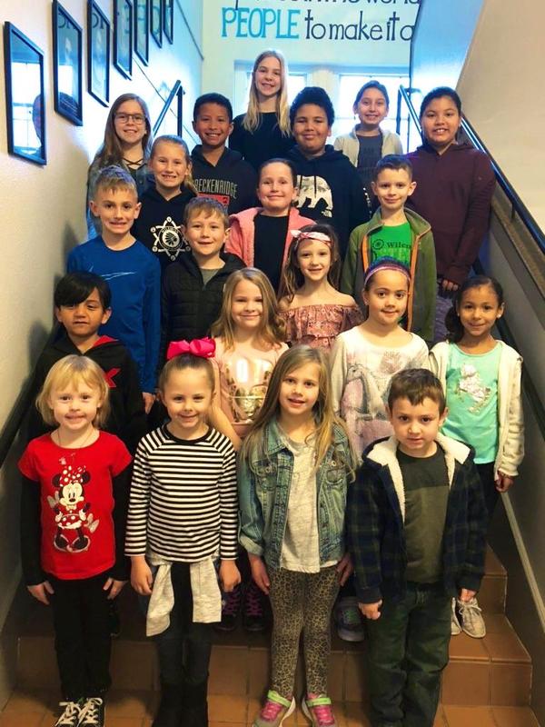 Group of 20 students pose on stairs