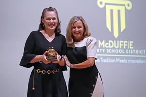 Elizabeth Hahn accepts the Teacher of the Year trophy from Superintendent Dr. Mychele Rhodes