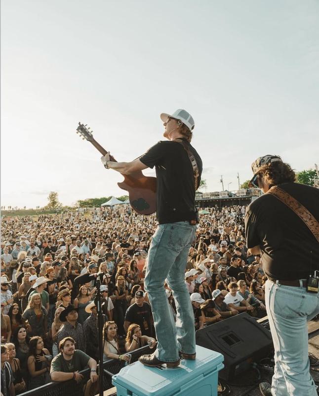 gage mcneely playing guitar, crowd in background