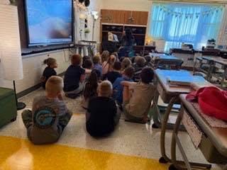principal reads in front of class