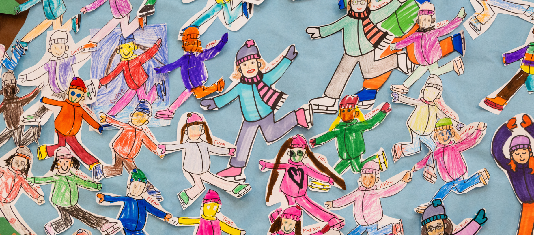 Colorful drawings of children ice skating are displayed on a blue backdrop.