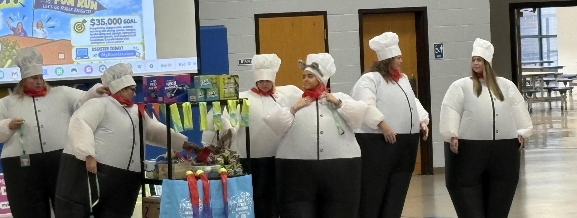 Group of people in inflatable chef costumes at a fundraising event.