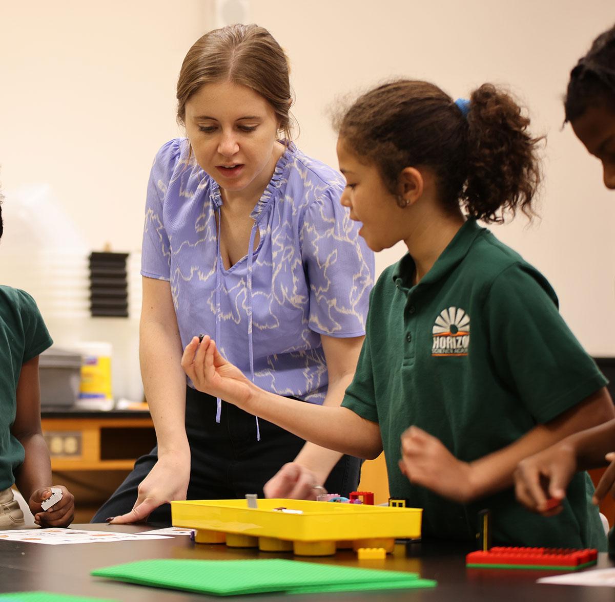 HSA St. Paul Teacher and student interacting at a classroom desk
