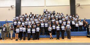 group of seniors holding "ask me about ___ college" signs