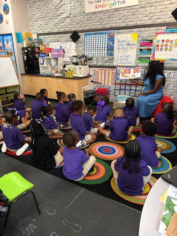Scholars sitting listening to a story being read to them.