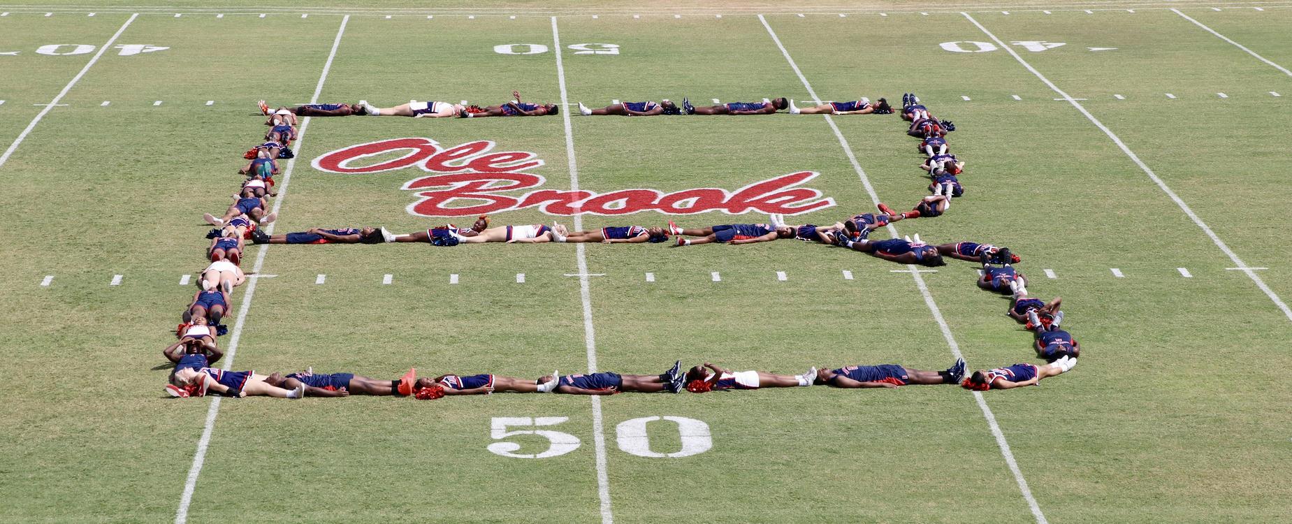 A group of athletes forming the letter B on a football field with the name 'Ole Brook.'