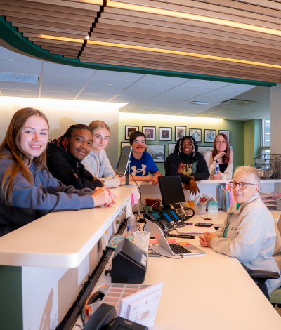 Students and DVFriends Receptionist smiling at the front desk