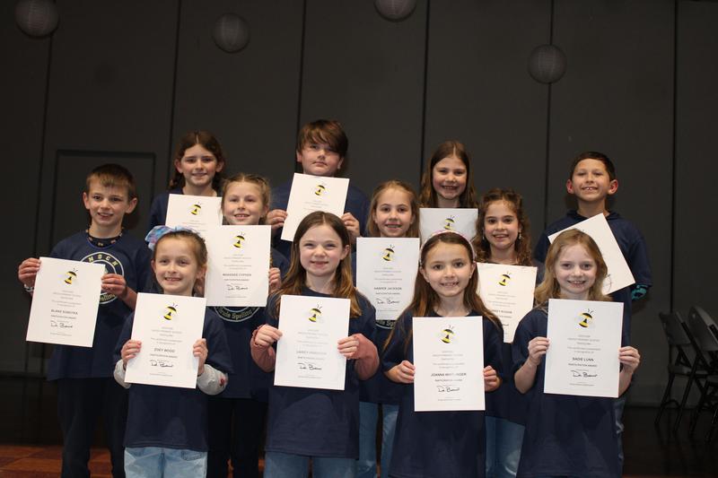 group of 12 spellers holding certificates smiling