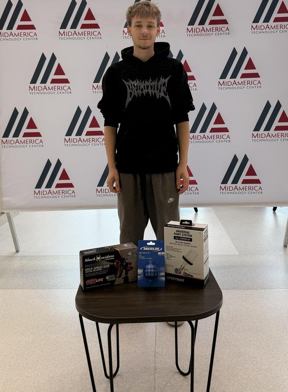 student standing behind a small table with tool variety
