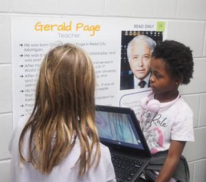 Two students learn about local heroes in their own hall of fame walk.