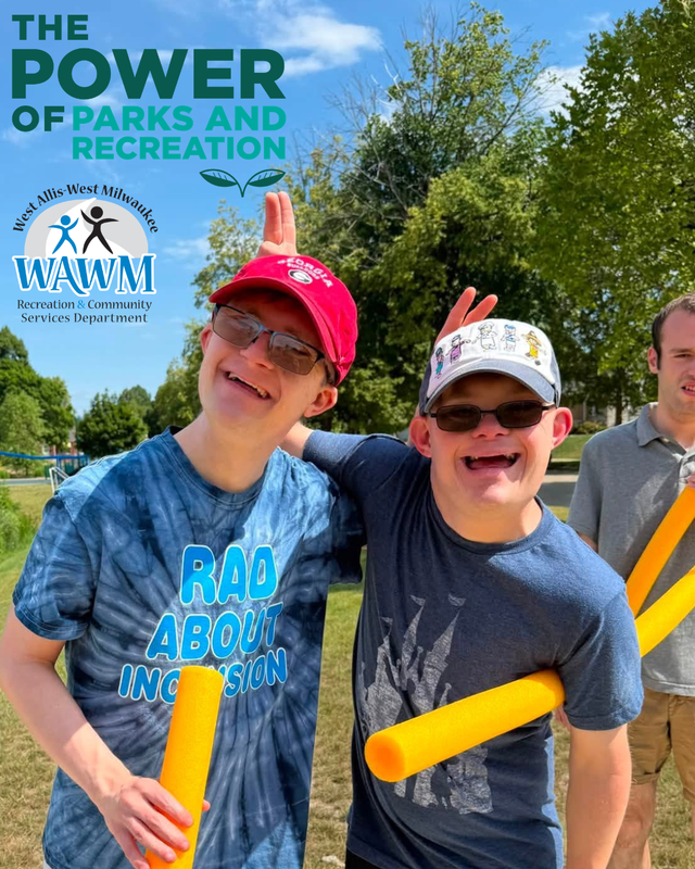 Picture of two young men smiling holding yellow pool noodles
