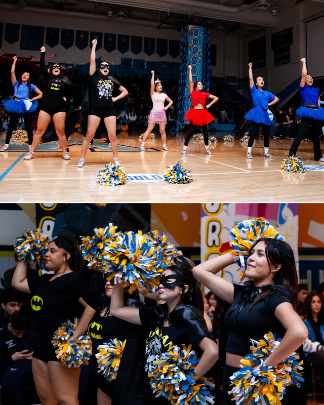 Cheerleaders and dancers in costumes perform with pom-poms on a gym floor while the crowd watches.