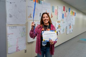 Sarah Denning posing with certificate and balloons