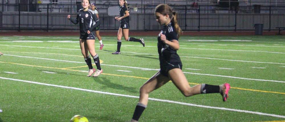 Girls playing soccer on a field