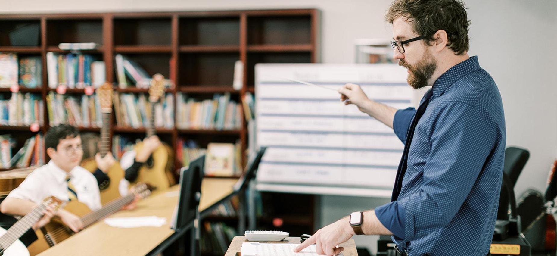 Music teacher leads students in a guitar class