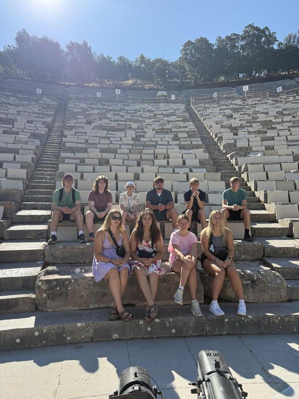 MCS students sit on the steps of an ancient Greek site.