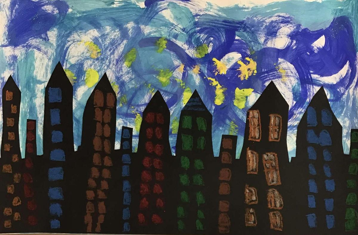 Silhouette of buildings against a swirling blue sky with hints of color.