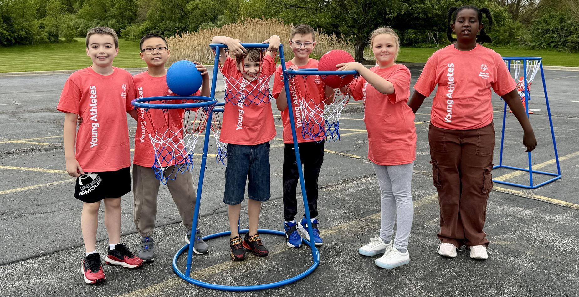 Group photo of the student helpers for the Dr. Julian Rogus School Young Athletes Event taken by the basketball hoop game.