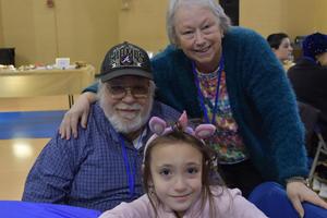 Two grandparents posing with their grandaughter.