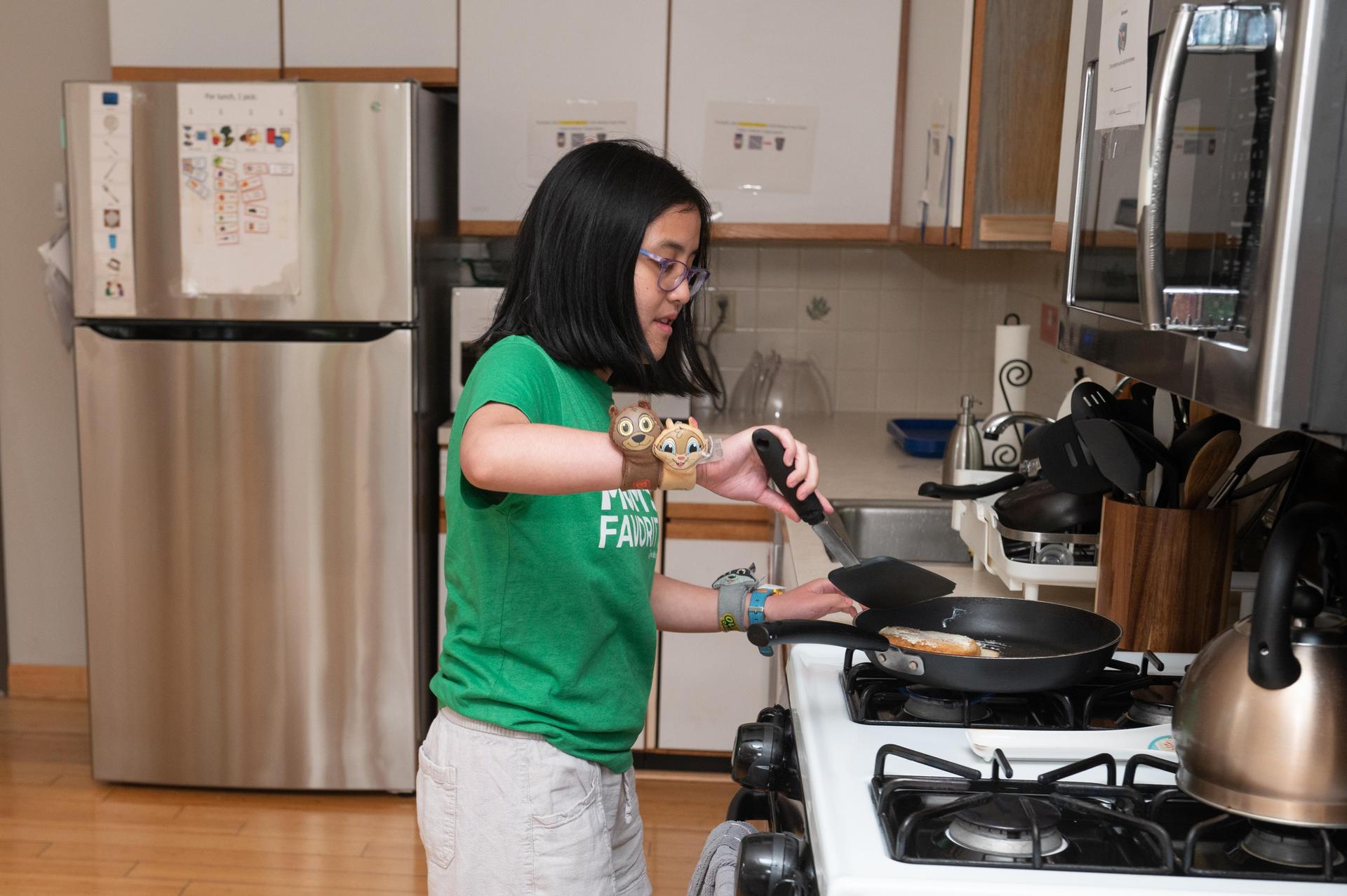 Student in green shirt cooking.