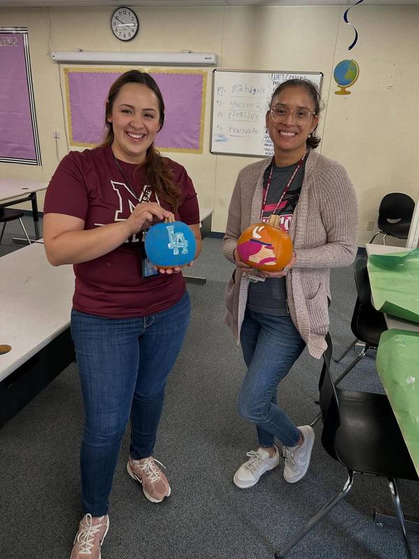 students holding up pumpkins