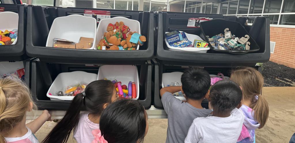 Students looking in toy bins to pick out a toy for having perfect attendance