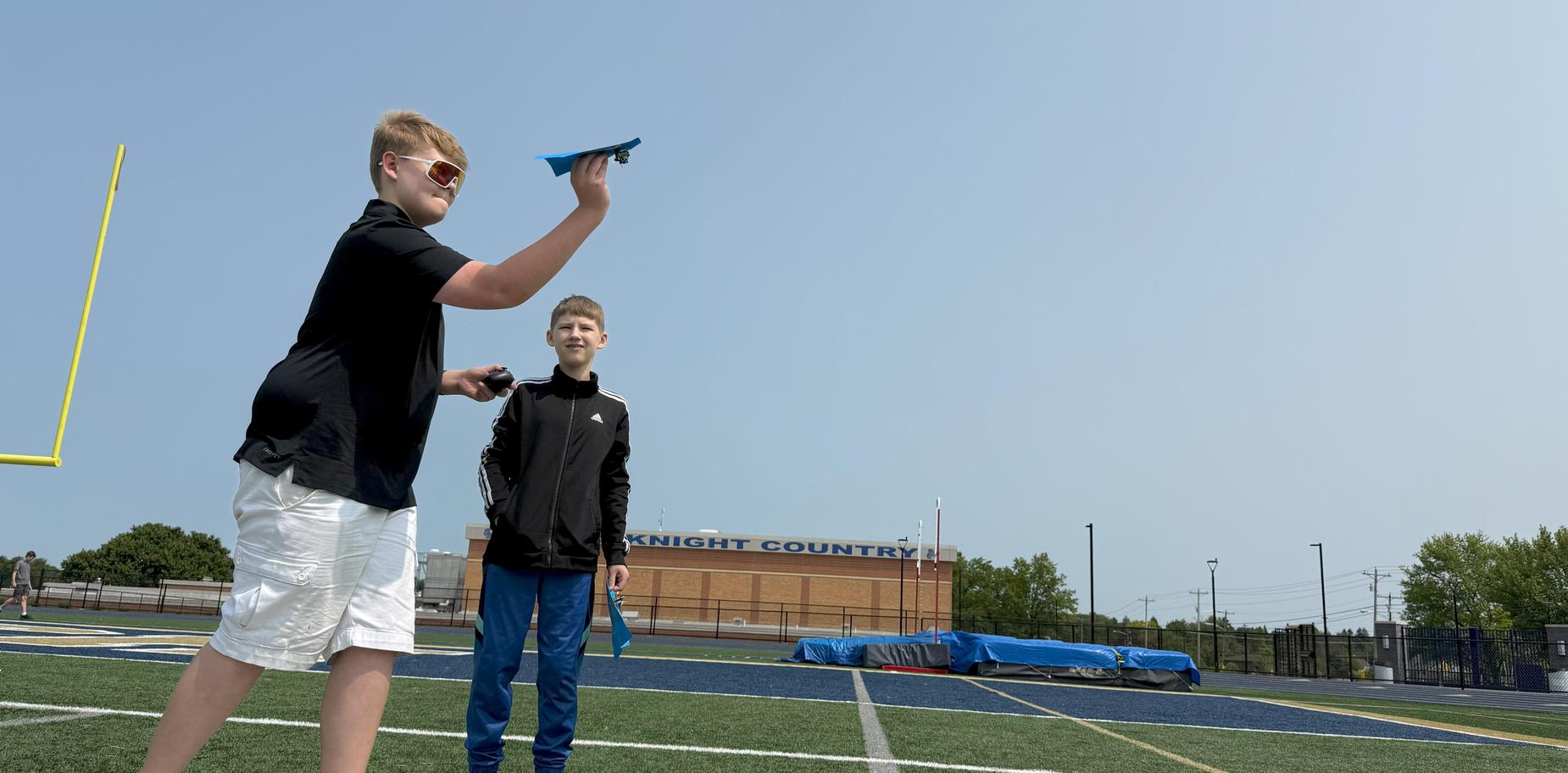 boy aiming to throw a paper glider