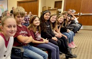 Students sitting down looking at the camera