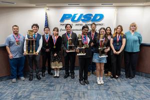 Harmony Magnet Academy's Academic Decathlon team poses with their trophies and medals at the PUSD Board meeting after winning their fourth consecutive Tulare County championship.