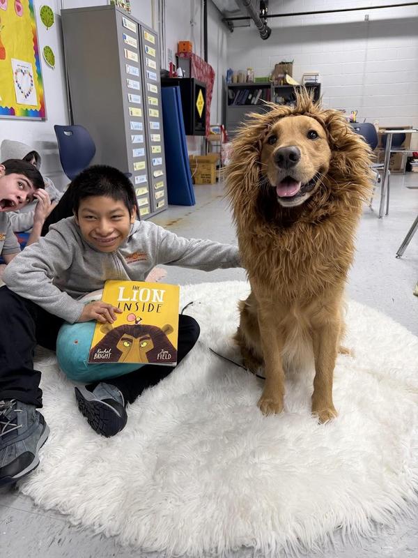 student and therapy dog dressed like lion