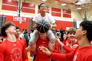 Freiheit Elementary School student Isaiah Valero with Canyon High School basketball players