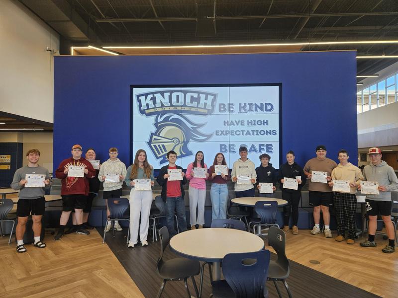 large group of students posing in a cafeteria setting