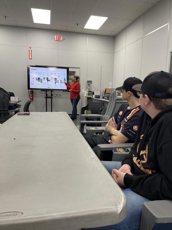 two boys sitting at table watching presentation on screen