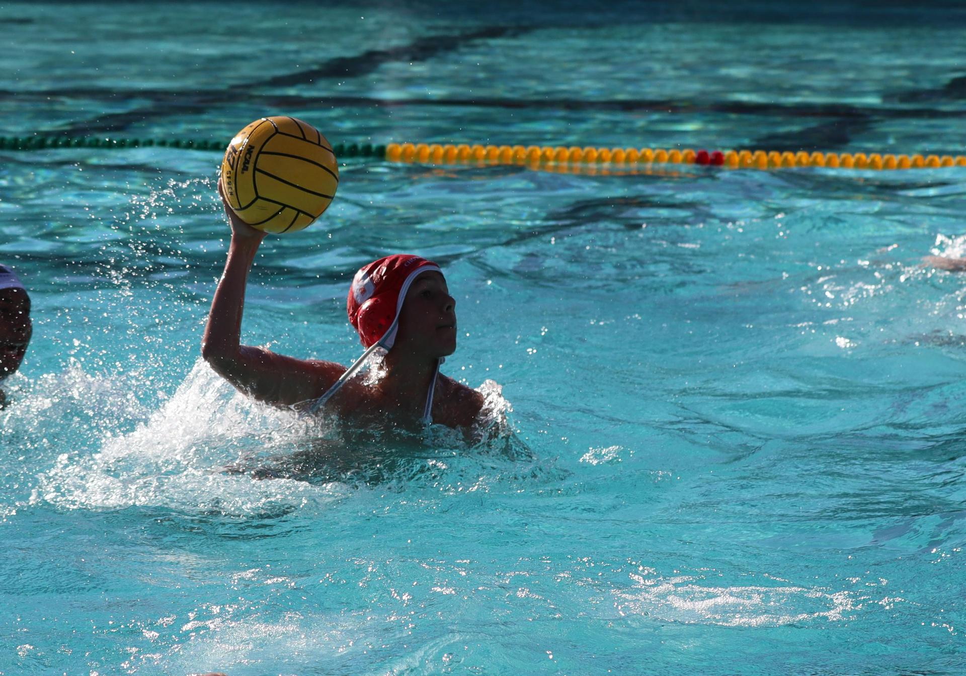 boys water polo players in action against hoover