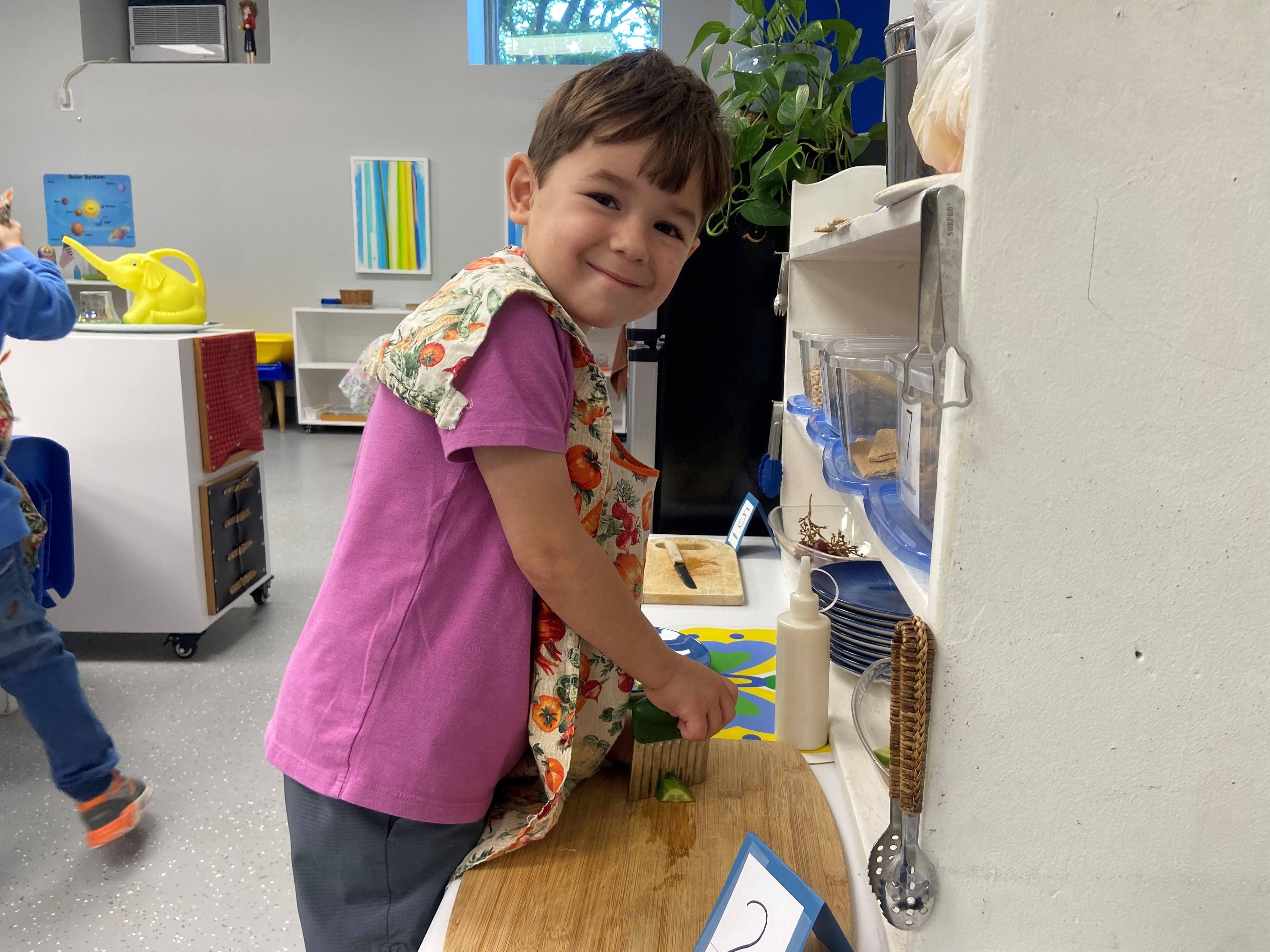 Montessori student cutting food