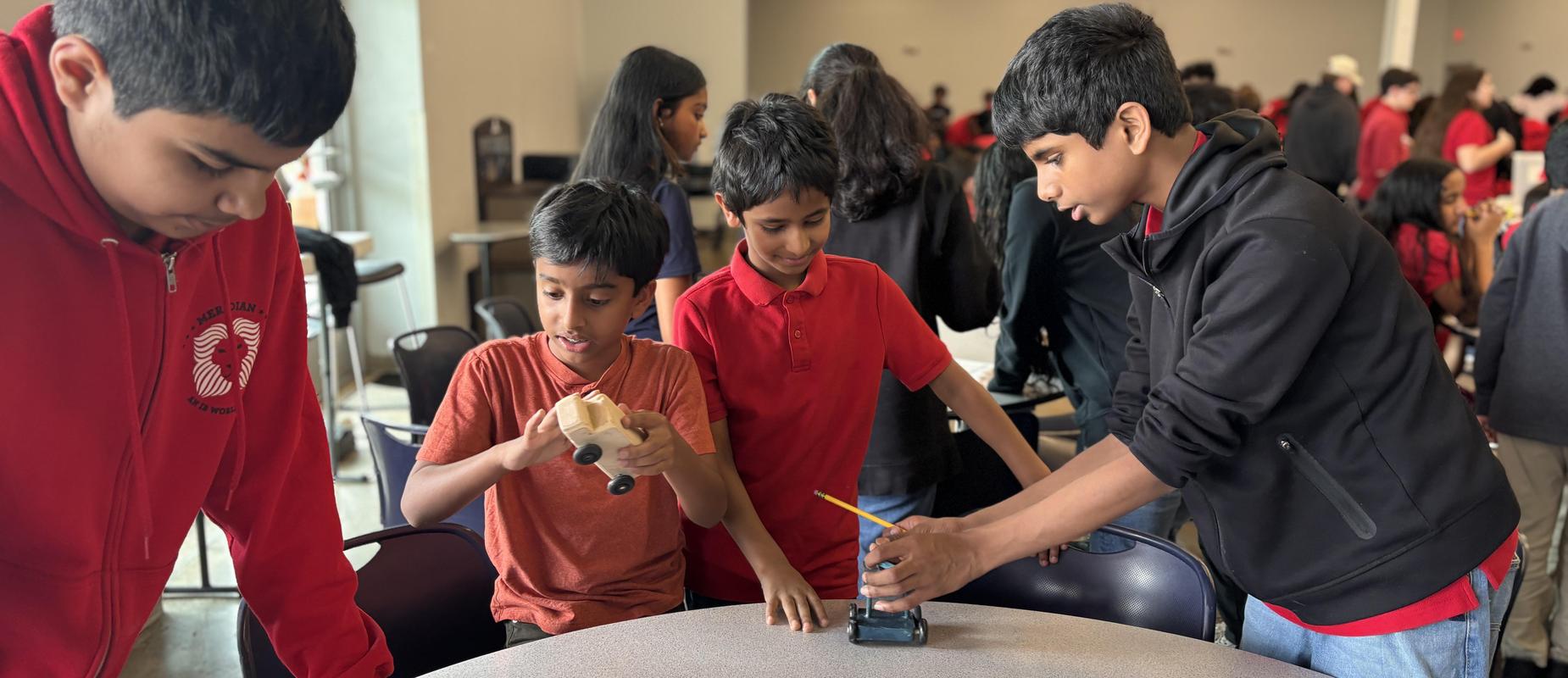 Students talk about wooden toy cars and write down feedback
