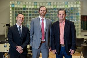 three men standing together smiling