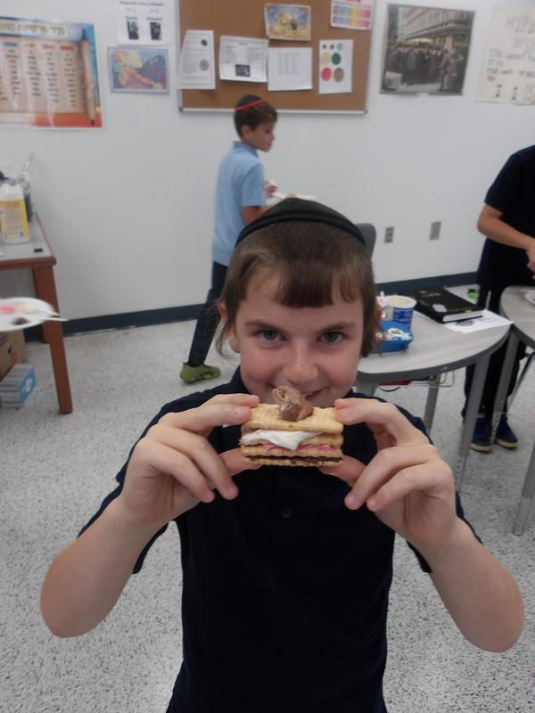 A fourth grade student showing his shofar sandwich.
