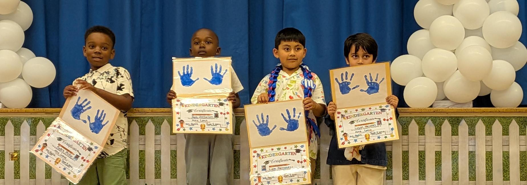 Four little kids holding certificates.