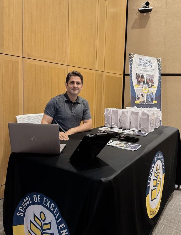 A Nashville School of Excellence team member welcomes visitors at the school's information booth during the 2026 National Civics Bee.