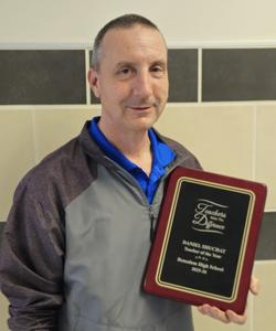 Image of a man holding his teacher of the year plaque