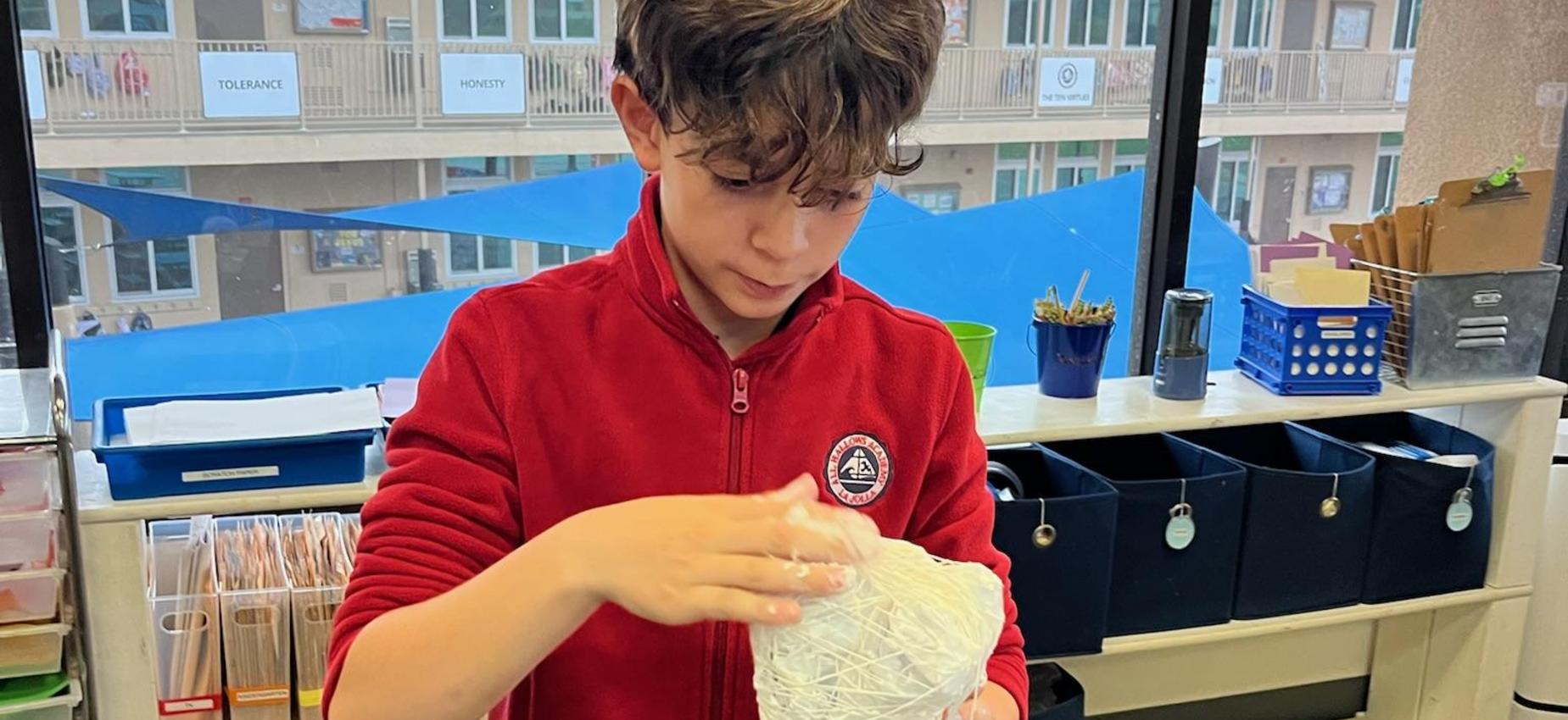 6th grade student in art elective building a 3d art piece