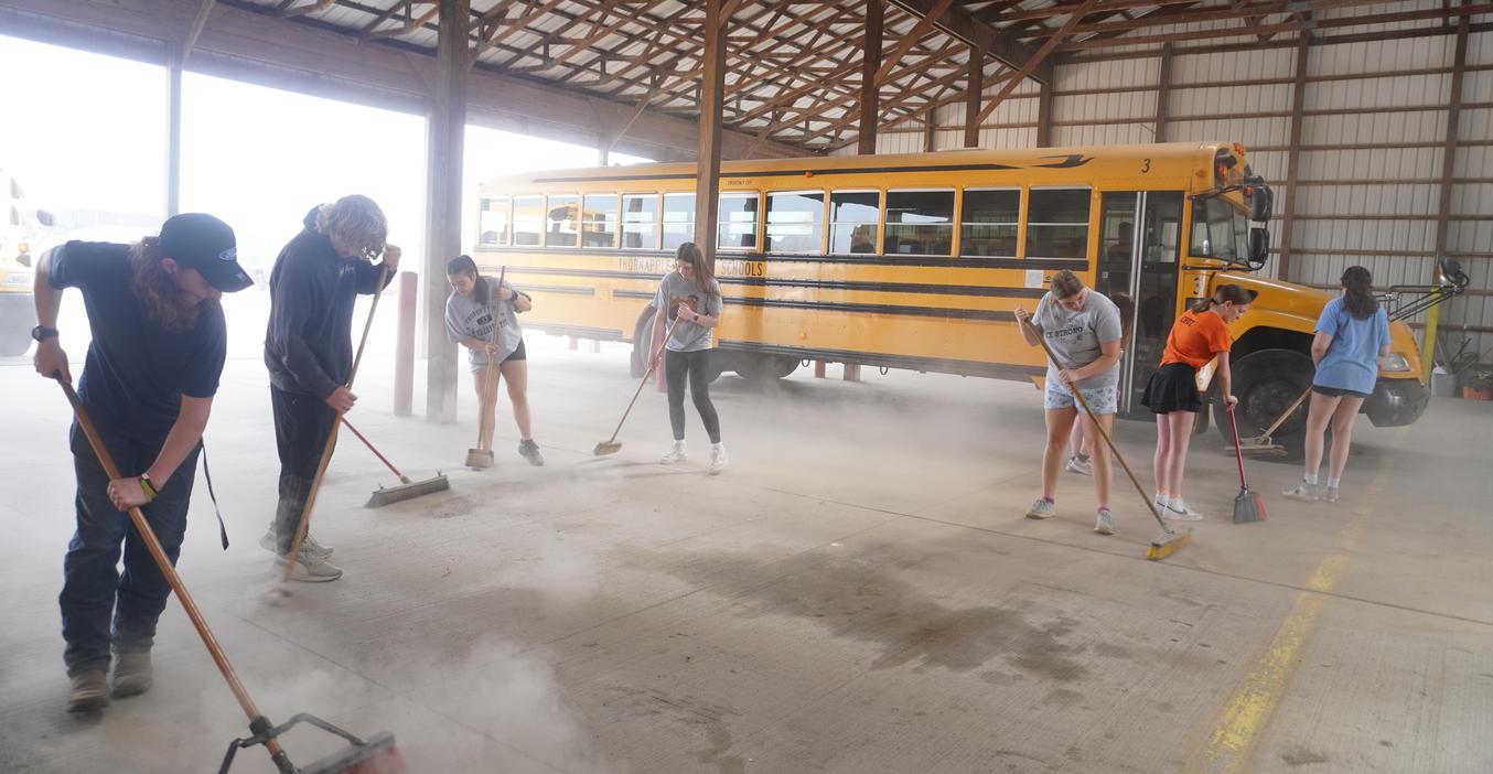 TK students help clean out the bus garage during the annual service day.