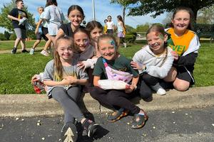 Level Green Third Graders Charlotte Teoli, Gemma Armbrust, Ruby Mortimore, Aubrey Divens, Ryann Dulemba, Clara Briscoe, and Paisley Hitchen sit down on the curb to take a break from the day’s activities