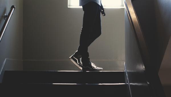 Silhouette of a person on stairs in black shoes.