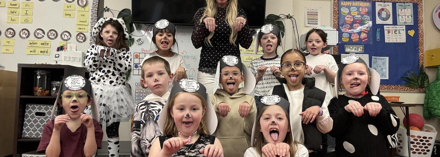 A group of children and a teacher posing together in animal-themed costumes with playful expressions.
