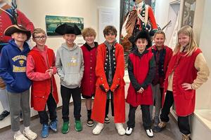 Sunrise Elementary students Adam Hetrick, Jack Wetzel, Cam Szramowski, Caden Hoyman, Bekir Guler, Boden Ruzich, Scarlett Owens, and Mera Kmetz try on some soldier uniforms at Bushy Run Battlefield