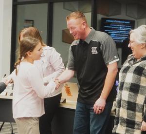 A Page student presents a token of thanks to the board of education vice president.
