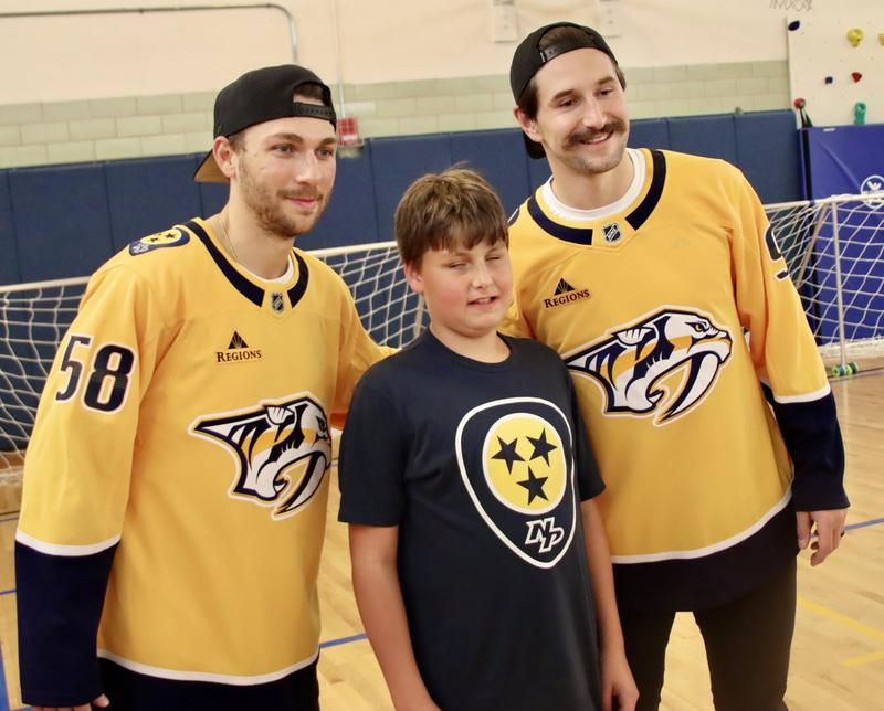 Two members of the Nashville Predators pose with a TSB student after the game of goalball.